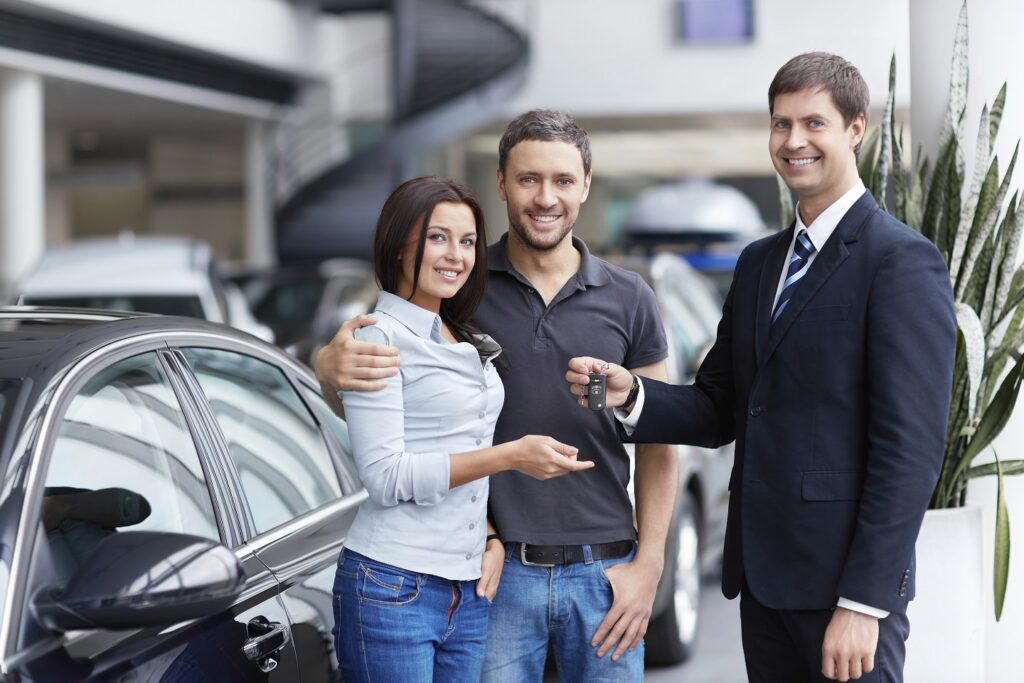 Owner Financed Used Cars for Sale USA: Seller and a couple of with the keys to car